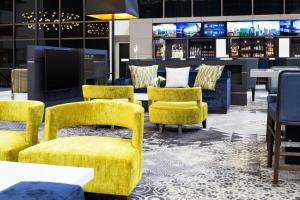 a lobby with yellow chairs and a bar at Sheraton Bloomington in Bloomington