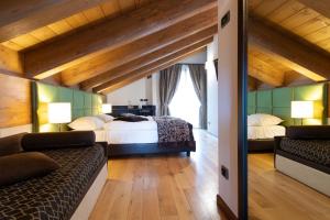 a bedroom with two beds and a large window at Hotel Vedig in Santa Caterina Valfurva