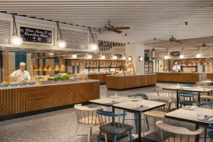 a restaurant with tables and a chef in the kitchen at Four Points by Sheraton Hong Kong, Tung Chung in Hong Kong