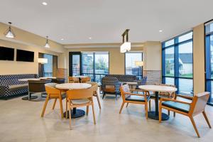 un restaurante con mesas, sillas y ventanas en TownePlace Suites by Marriott Indianapolis Downtown en Indianápolis