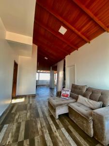 sala de estar con sofá y techo de madera en Barra da Lagoa Guest House en Florianópolis