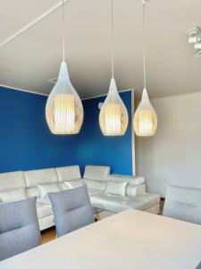 a room with a couch and chairs and lights at Homely Stay Apartment 1 in Sankt Pölten
