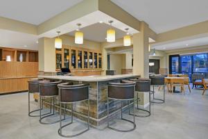 a lobby with a bar with stools and tables at TownePlace Suites by Marriott Indianapolis Downtown in Indianapolis