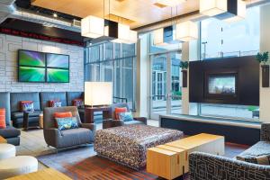 a hotel lobby with a tv and furniture at Aloft Hotel Frisco in Frisco