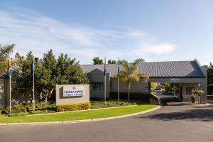 un hotel con un cartel frente a una carretera en Protea Hotel by Marriott Cape Town Tyger Valley en Bellville