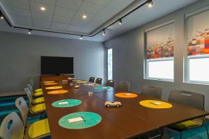 una sala de conferencias con una larga mesa de madera y sillas en Aloft College Station en College Station