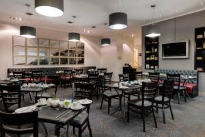 un comedor lleno de mesas y sillas en Protea Hotel by Marriott Cape Town Tyger Valley, en Bellville