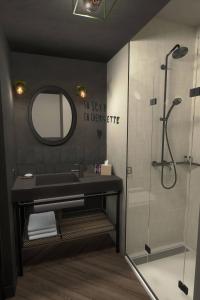 a bathroom with a sink and a shower with a mirror at Moxy Lille City in Lille