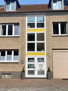 クサンテンにあるFeriendomizil Mühlenblickの白いドアと窓のあるレンガ造りの家