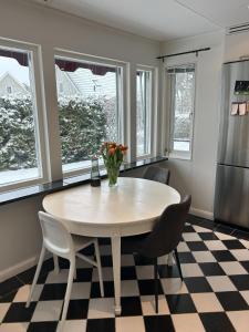 cocina con mesa, sillas y nevera en Villa Stockholm Täby, en Estocolmo