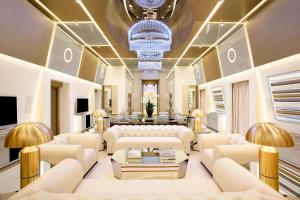 a living room with white furniture and a chandelier at Excelsior Hotel Gallia, a Luxury Collection Hotel, Milan in Milan