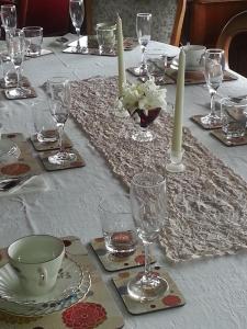 a table with glasses and candles on a white table cloth at Alexandria Bed and Breakfast in Wynyard