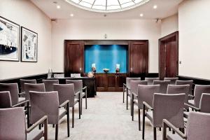 a room with rows of chairs in a room with a screen at Threadneedles, Autograph Collection in London