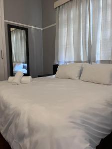 a large white bed in a bedroom with a window at 28 ON WOOD in Pietermaritzburg