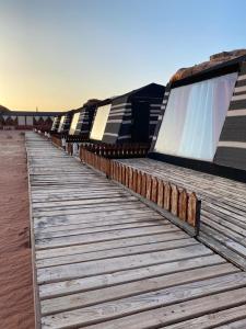 a row of benches on a wooden boardwalk at Discover the life of Wadi Rum in Wadi Rum