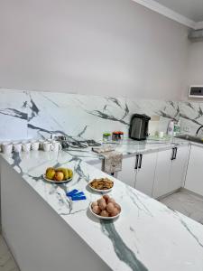 a kitchen with three bowls of fruit on a counter at Hostel_inJoy in Shymkent