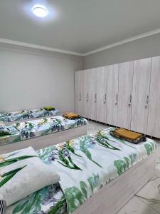 a room with three beds sitting on the floor at Hostel_inJoy in Shymkent