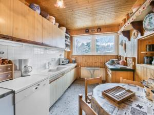 a kitchen with wooden cabinets and a table in it at Appartement Megève, 4 pièces, 8 personnes - FR-1-453-14 in Megève