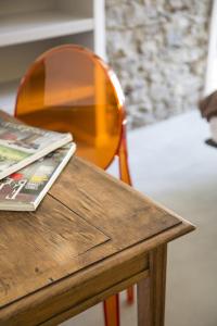a wooden table with a wooden chair and a table with a newspaper at Ca Bussun in Domodossola