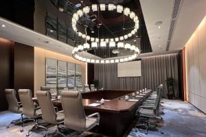 una sala de conferencias con una mesa grande y sillas en Fairfield by Marriott Taizhou Bay, en Taizhou