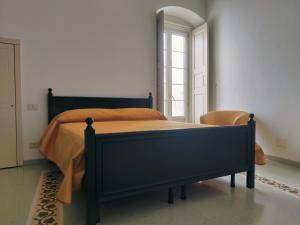 a bedroom with a bed with an orange bedspread at Dimora del Sole in Martina Franca