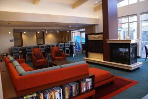 biblioteka z kanapą, kominkiem i krzesłami w obiekcie Residence Inn Pittsburgh Monroeville/Wilkins Township w mieście Monroeville
