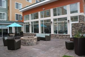 a patio with chairs and tables and an umbrella at Residence Inn Pittsburgh Monroeville/Wilkins Township in Monroeville
