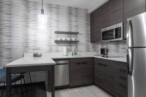 uma cozinha com um frigorífico de aço inoxidável e uma mesa em Residence Inn by Marriott Anderson Clemson em Anderson