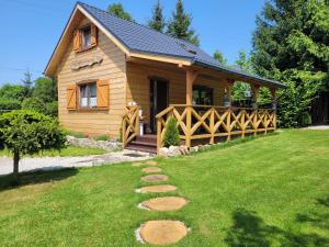 a log cabin with a walkway in front of a yard at Lawendowy domek in Mysłakowice