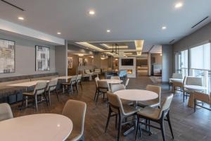 a dining room with tables and chairs and windows at Residence Inn by Marriott Anderson Clemson in Anderson