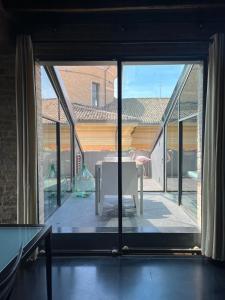 Habitación con ventana grande y patio con mesa. en Ardesia Exclusive Apartament, en Parma