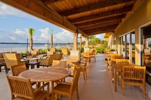 un patio con mesas y sillas y el océano en TownePlace Suites by Marriott Fort Walton Beach-Eglin AFB, en Fort Walton Beach