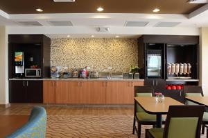 a restaurant with a kitchen with a counter and tables at TownePlace Suites by Marriott Fort Walton Beach-Eglin AFB in Fort Walton Beach