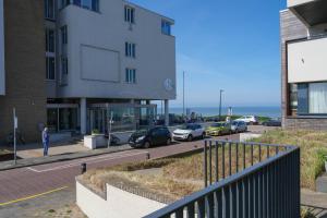 un bâtiment avec des voitures garées dans un parking dans l'établissement Seepaertje 2, à Noordwijk aan Zee