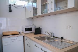 een keuken met een wastafel en een magnetron bij Seepaertje 2 in Noordwijk aan Zee
