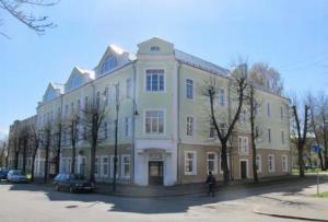 a large building with a person walking in front of it at Avers House in Narva