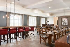 a restaurant with tables and chairs and a bar at Four Points by Sheraton Fargo Medical Center in Fargo