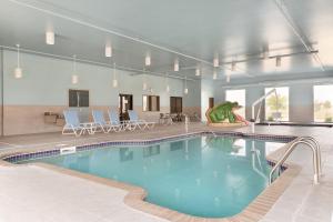 a large swimming pool in a building with chairs at Four Points by Sheraton Fargo Medical Center in Fargo