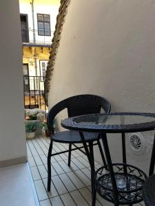 a small table and chair on a balcony at Apartmani Maximus in Subotica