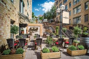 un patio al aire libre con sillas, mesas y chimenea en Le Méridien Stuttgart, en Stuttgart