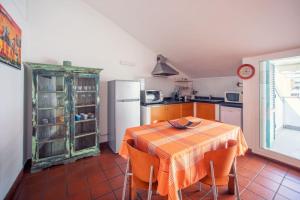 een keuken met een tafel met stoelen en een koelkast bij La casa di Marina in Sanremo
