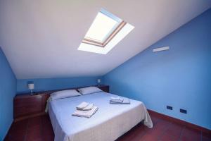 Un dormitorio azul con una cama con toallas. en La casa di Marina, en San Remo