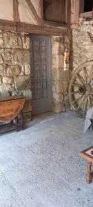a door to a stone building with a wooden wheel at Las Cafourques Chambre d'Hotes in Ségalas