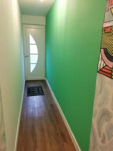 Cette chambre est dotée d'un mur vert et d'une porte. dans l'établissement Les pléiades, à Fort-Mahon-Plage