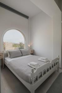 米科利維亞的住宿－Depi's Sea Horizon Apartments，白色卧室设有一张大床和拱形窗户