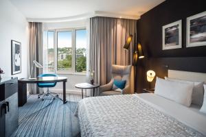 um quarto de hotel com uma cama e uma secretária em Le Méridien Stuttgart em Estugarda