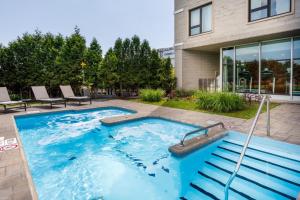 a swimming pool in a yard next to a house at Four Points by Sheraton Lévis Convention Centre in Lévis