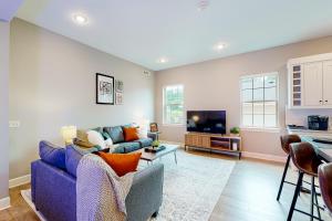 Bentonvilla في بنتونفيل: غرفة معيشة مع أريكة زرقاء وتلفزيون