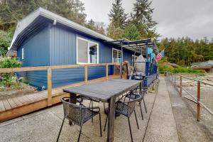 a blue tiny house with a table and chairs at Good Beach Getaway in Coupeville