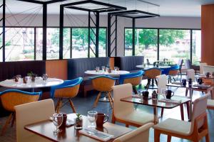 un restaurante con mesas, sillas y ventanas en Marriott at the University of Dayton en Dayton